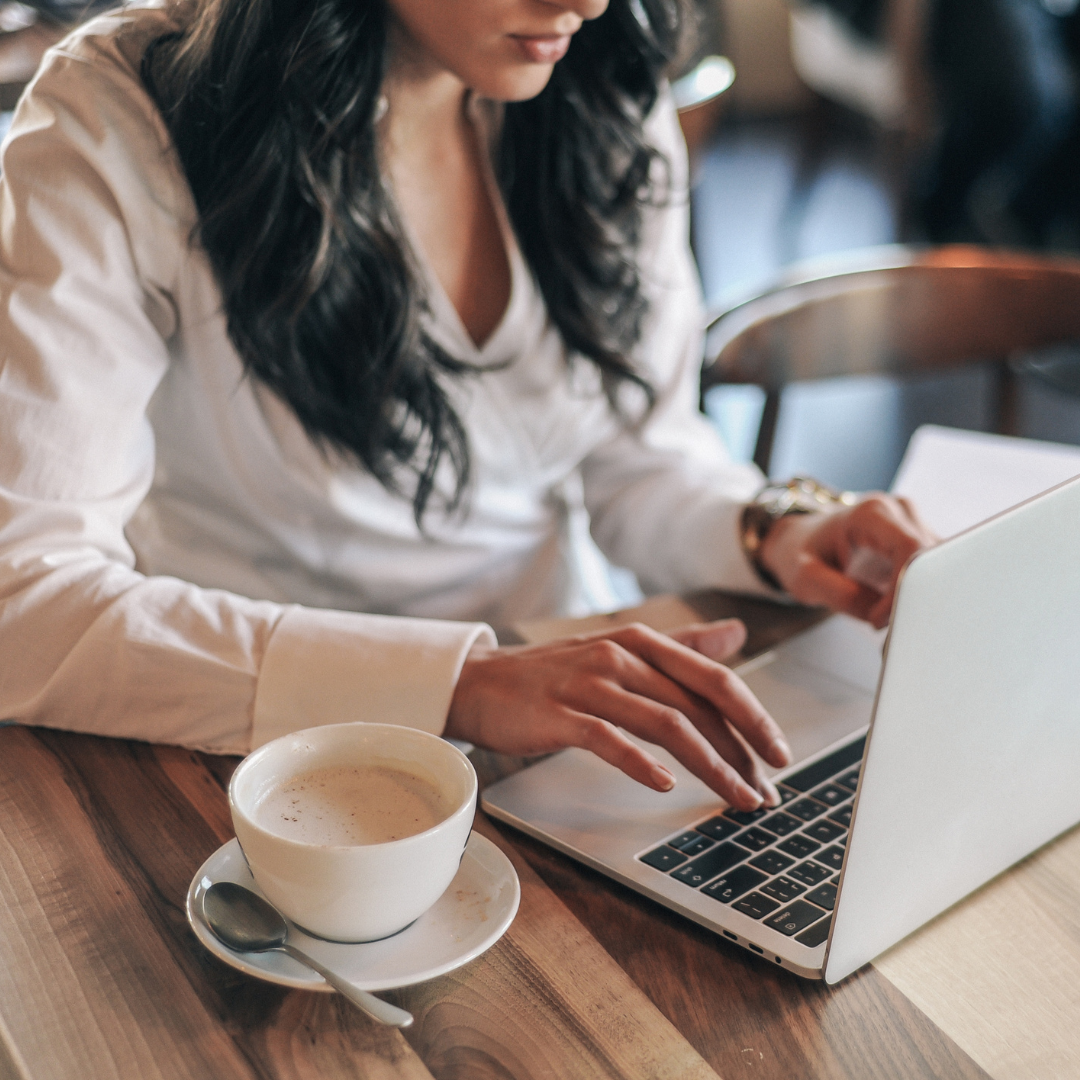 Woman working on laptop with coffee