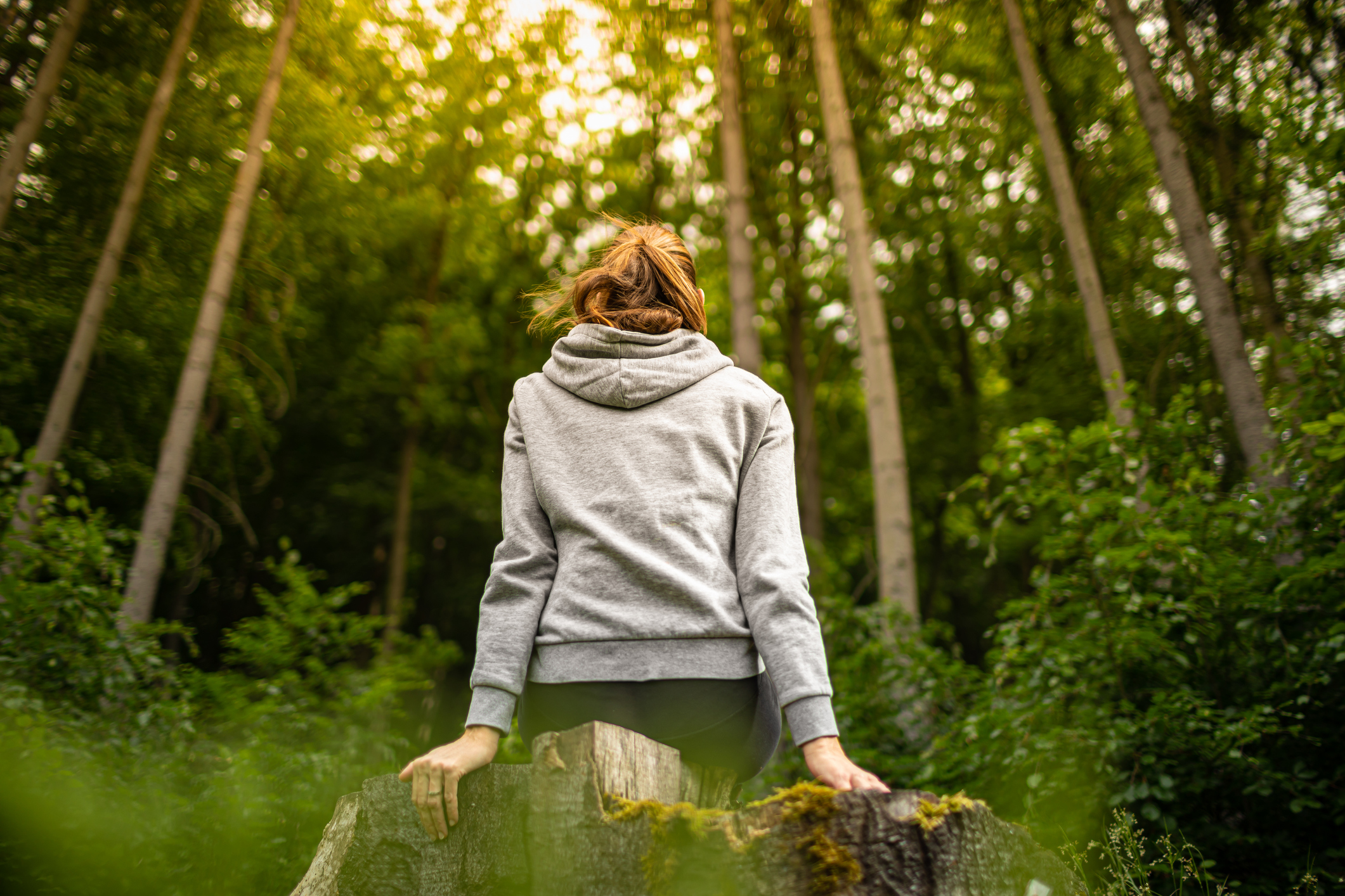 Young woman sitting in a quiet peaceful nature forest setting